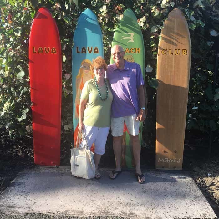 Bobby with Wife in front of Surfboards